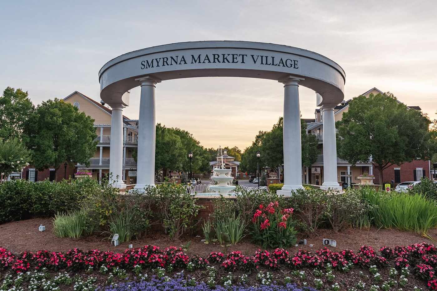 A columned entrance arch and planted beds at the center of a small Georgia town at dusk
