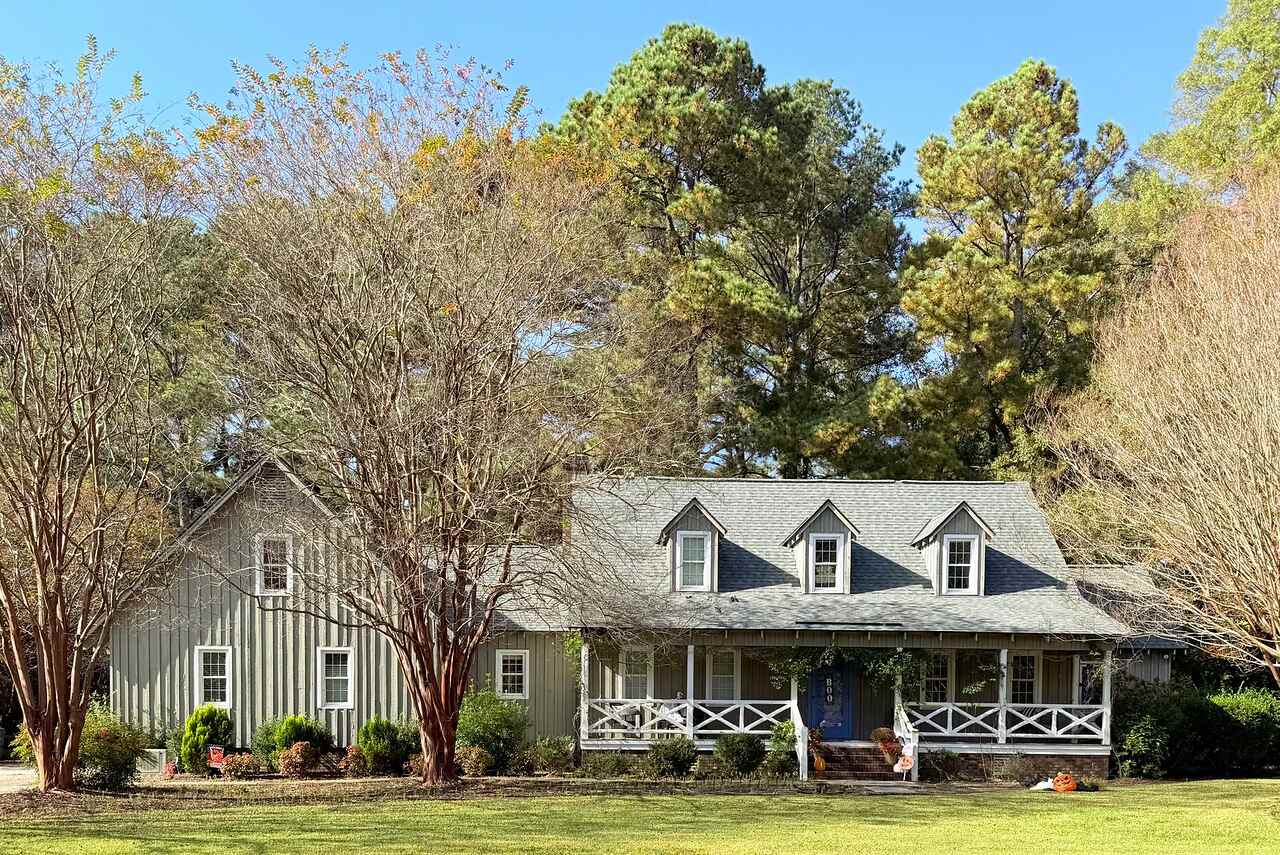 A ranch-style house surrounded by mature trees turning for autumn