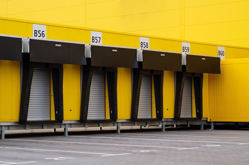 A row of closed loading bay doors along an industrial wall