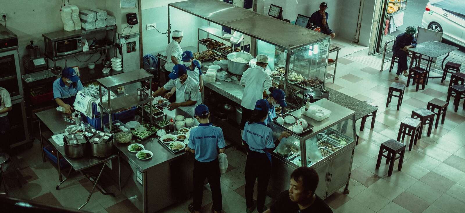 A commercial kitchen seen from above with the line under preparation