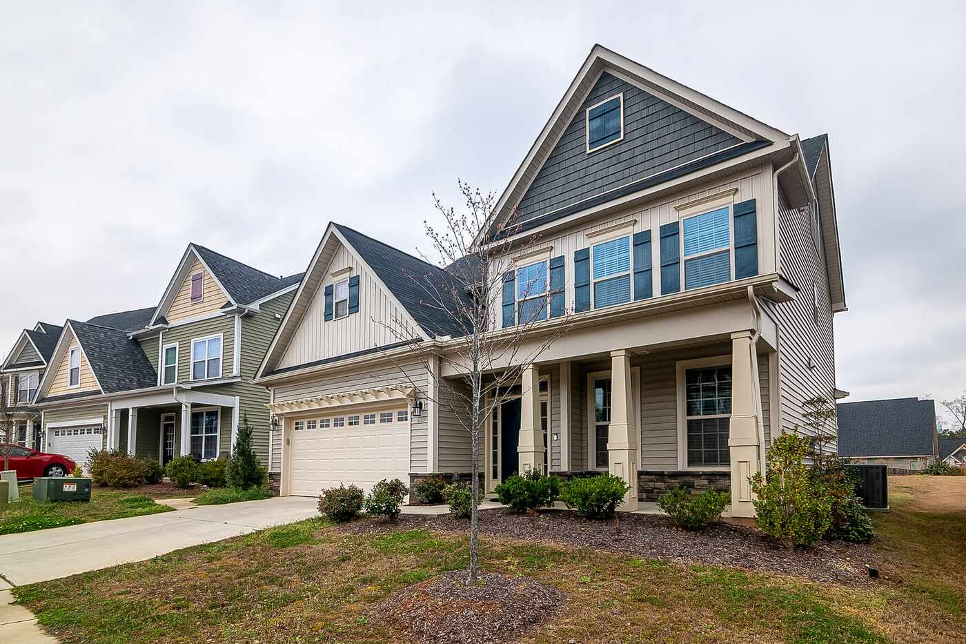 A row of newer suburban houses with garages, driveways and landscaped lawns